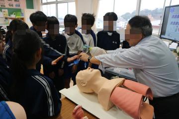 教室で、救急救命士体験講座の講師からの話を真剣に聞いている生徒たちの様子
