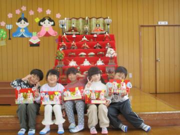 手作りのひな人形を持ってポーズをする子供たち