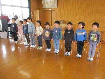 遊戯室で立って並んで歌を歌う子供たち
