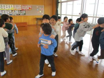 肩に手を置いて連なり、じゃんけん列車をする子供たち