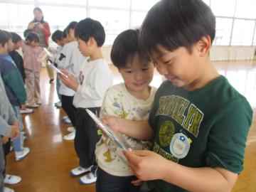 プレゼントの写真を一緒に見る二人の子供