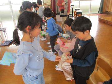 遊戯室で手作りのキーホルダーを渡す子供