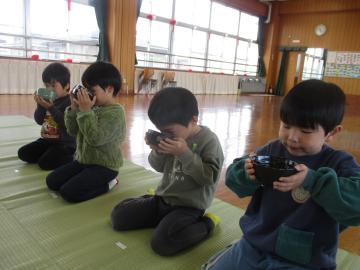 座敷の上で星座をして両手で器を持ち、抹茶を飲む子供たち