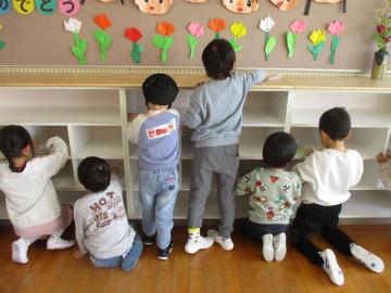 棚を雑巾で拭く子供