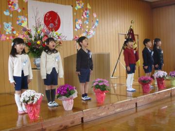 舞台に立って歌を歌う子供