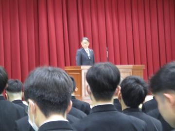 同窓会長がお祝いの言葉を述べる様子