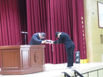 PTA会長から記念品を受け取る生徒の様子