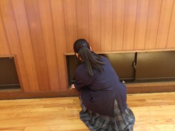 生徒が第二体育館の武道場の窓のサッシを掃除しています。