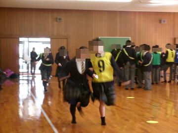 生徒が借り人競争を行い、選手と借りられた人が手をつないで走っています。