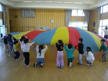 3クラスの子どもがそろってパラバルーンをしている様子