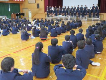 体育館で最後の全校集会で卒業式の歌を披露する6年生の様子