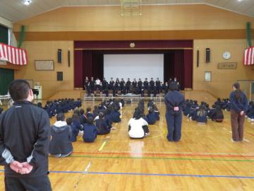 体育館の後方で涙ぐむ6年担任教員の様子