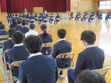 体育館で元担任の話を聞く6年生を見守る5年生の様子