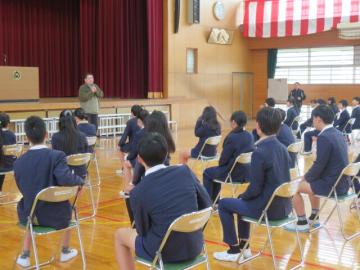 体育館で5年時担任からのお祝いのことばを聞く6年生の様子