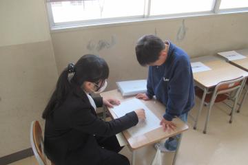 担任の先生から通知表について説明を受けている2年生の様子