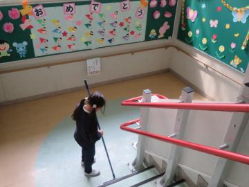 階段の掃除をする4年生と卒業お祝い掲示
