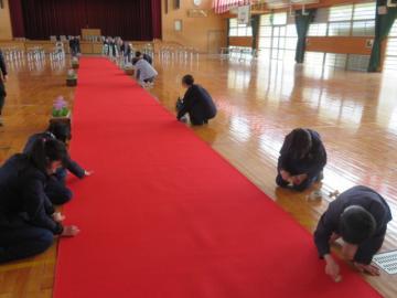 レッドカーペットのほこりをとる5年生