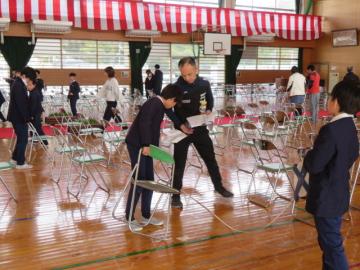 巻き尺を広げ座席の並びを整える5年生