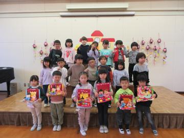 遊戯室で自分の作ったひな人形を持った園児たちの集合写真