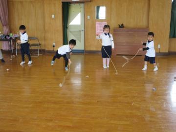 遊戯室でコマ回しのコマを投げている園児たちの様子