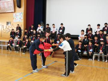 6年生が在校生代表に手作りぞうきんをプレゼントしているところ