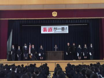 体育館の舞台上で、新生徒会執行部の生徒が並んでいる様子