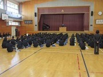 体育館に座り、校長の話を聞く生徒たちの様子