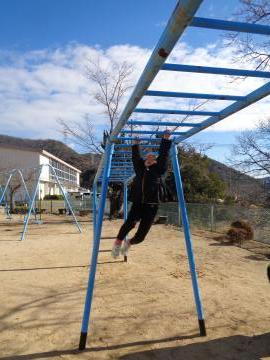 園児が増位小学校の運動場にある雲梯に挑戦している