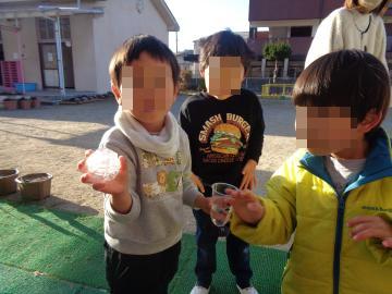 園庭に置いておいた水を入れたカップの中に氷が張っていて園児が触っている