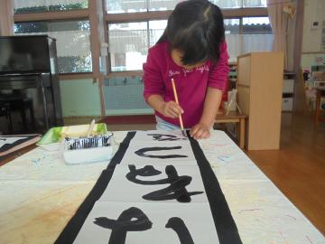 年長児が書初めではねつきの文字をかいている