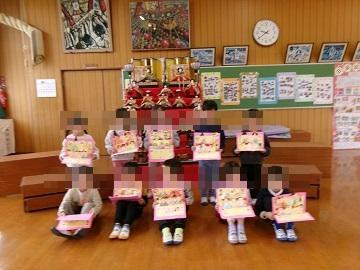 4歳児が雛人形の前で集合写真