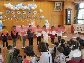 4歳児が5歳児のために歌のプレゼントをしている写真