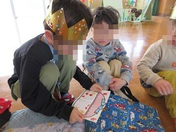 教室で座ってプレゼントを渡し合っている子供たち
