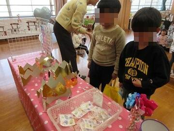 ビンゴの景品が並んでいるテーブルを見て景品を選んでいる子供たち