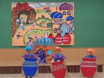 園児がありばばと盗賊の劇遊びをして、段ボールで作ったツボをもって立っている