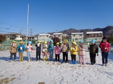 雪玉を持って園児皆で記念撮影をしている