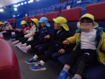 園児がプラネタリウムが始まるのを椅子に座って待っている