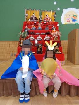 お雛様とお内裏様の衣装を着て記念撮影をしている