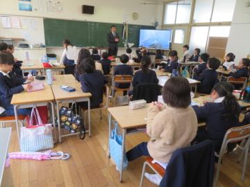 教室で椅子に座った児童たちが担任から最後の学級指導を受ける様子2