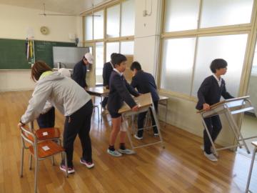 教室のつくえといすを運び出す5年生