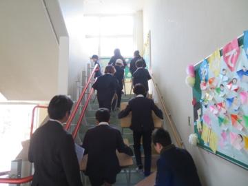 つくえといすをかかえて階段をのぼる5年生1