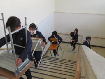つくえといすをかかえて階段をのぼる5年生2