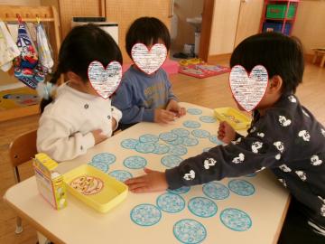 3歳児が教室のテーブルでカードゲームで遊んでいるところ