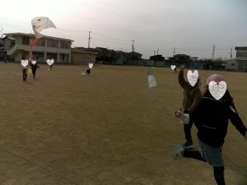 5歳児が小学校の運動場でたこあげをしているところ