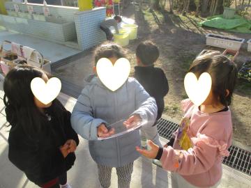 4歳児が園庭で氷をもって驚いているところ