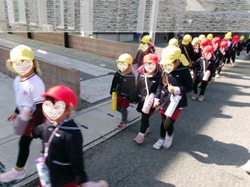 3歳児と4歳児が手を繋いで遠足にいっているところ