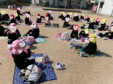 幼稚園の園庭でお弁当を食べているところ
