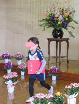 修了証書をもらって歩く子ども