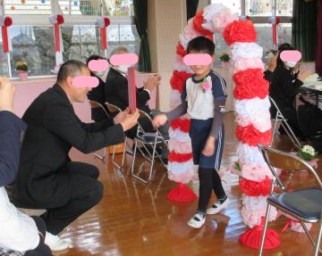 修了証書をお家の人に渡している子ども