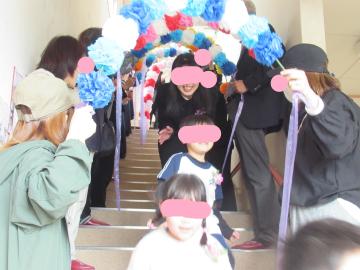 ご来賓・地域の皆さんがつくってくれた花道を通る修了児2